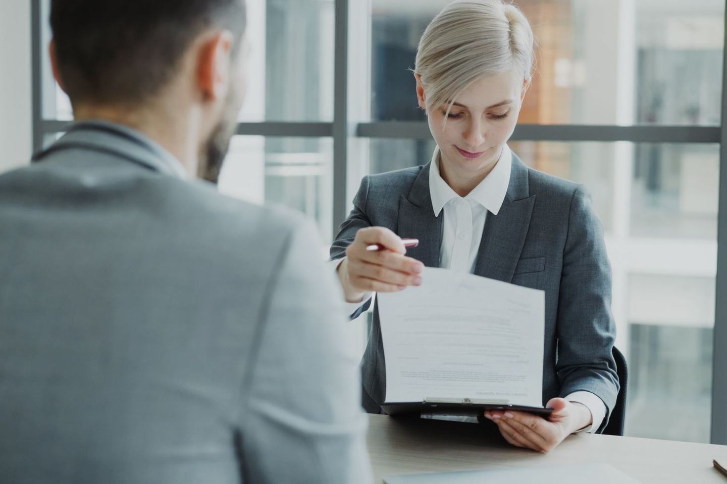 Two people at a desk comparing printed benefits plan documents