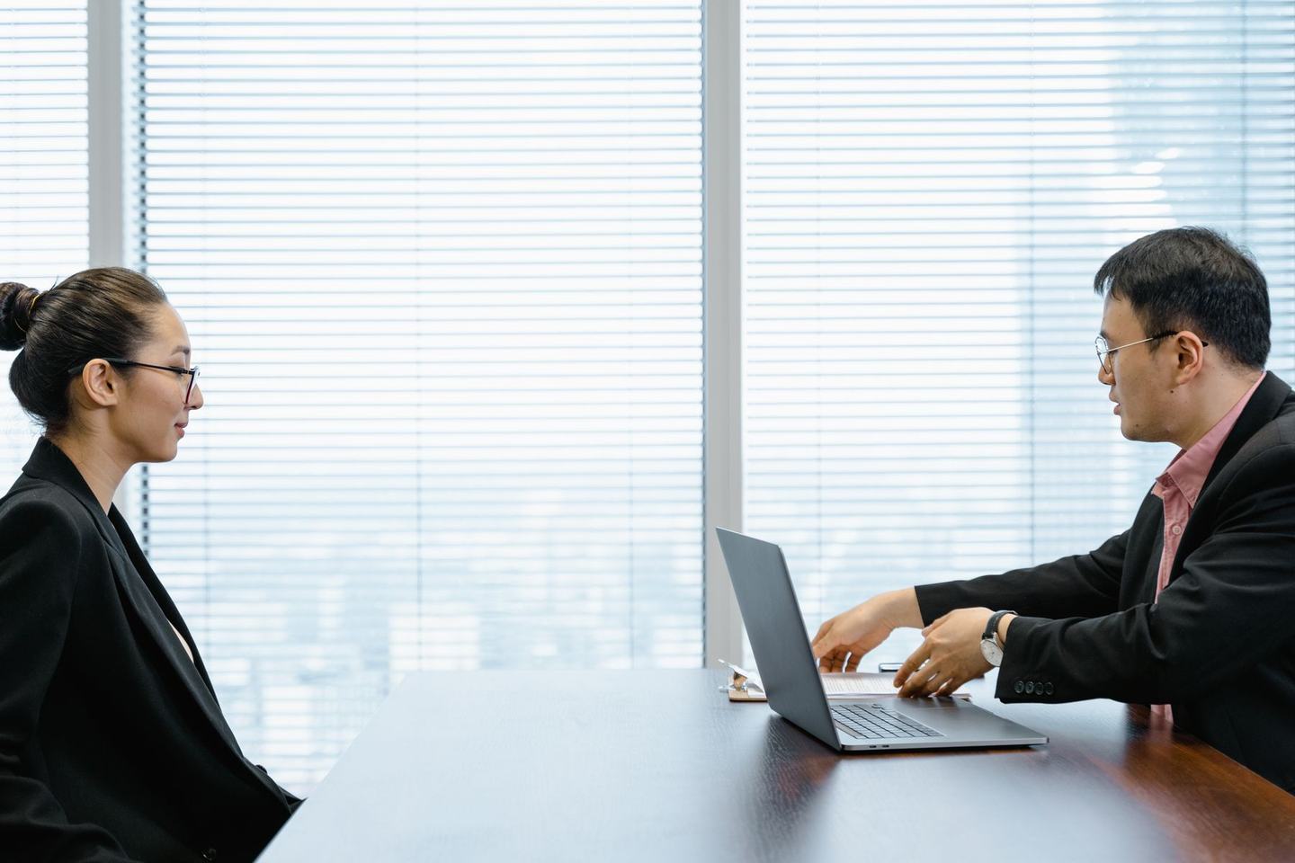 A candidate being interviewed by two people across a table in an office