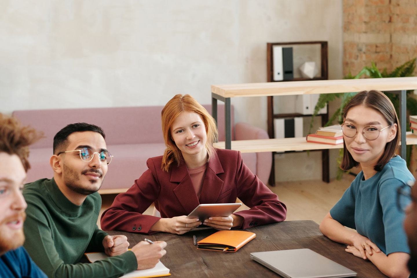 A small group in a workshop session around a table with a presenter